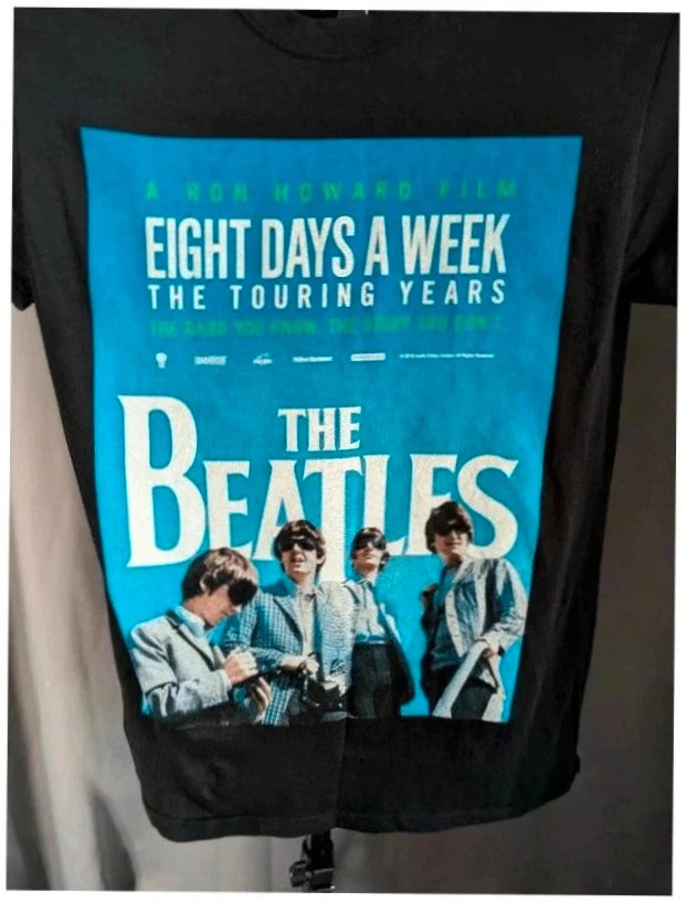 The Beatles black graphic tee featuring vibrant blue and white documentary print.