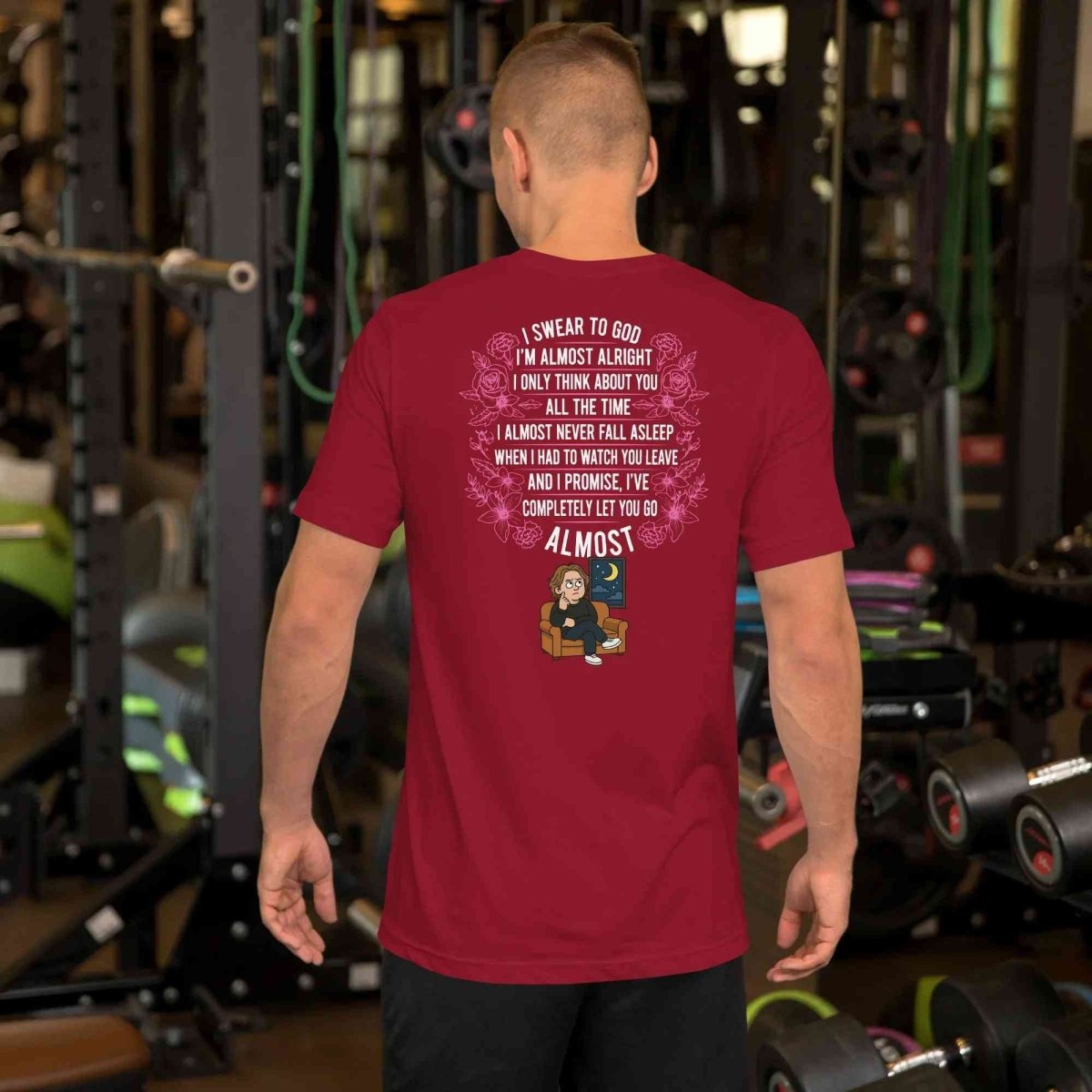 Man wearing red Lewis Capaldi lyrics t-shirt featuring song text and cartoon in gym setting