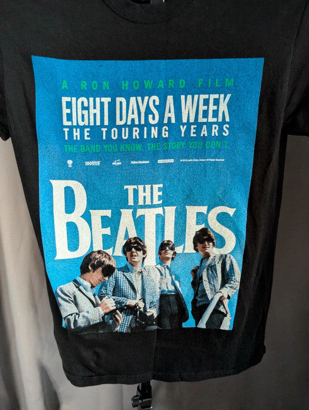 The Beatles black graphic tee featuring vibrant blue and white documentary print.