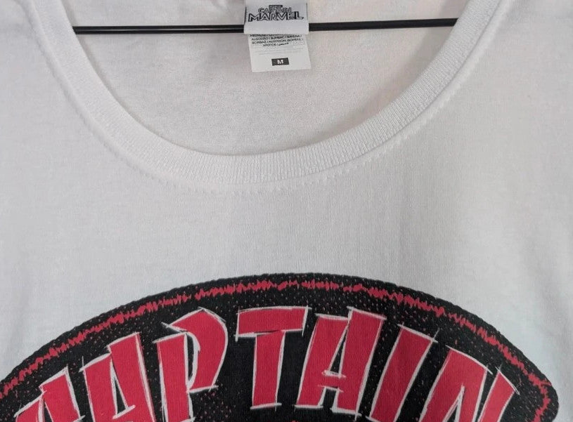 Marvel white graphic t-shirt featuring Captain Marvel print and retro patch-style lettering.