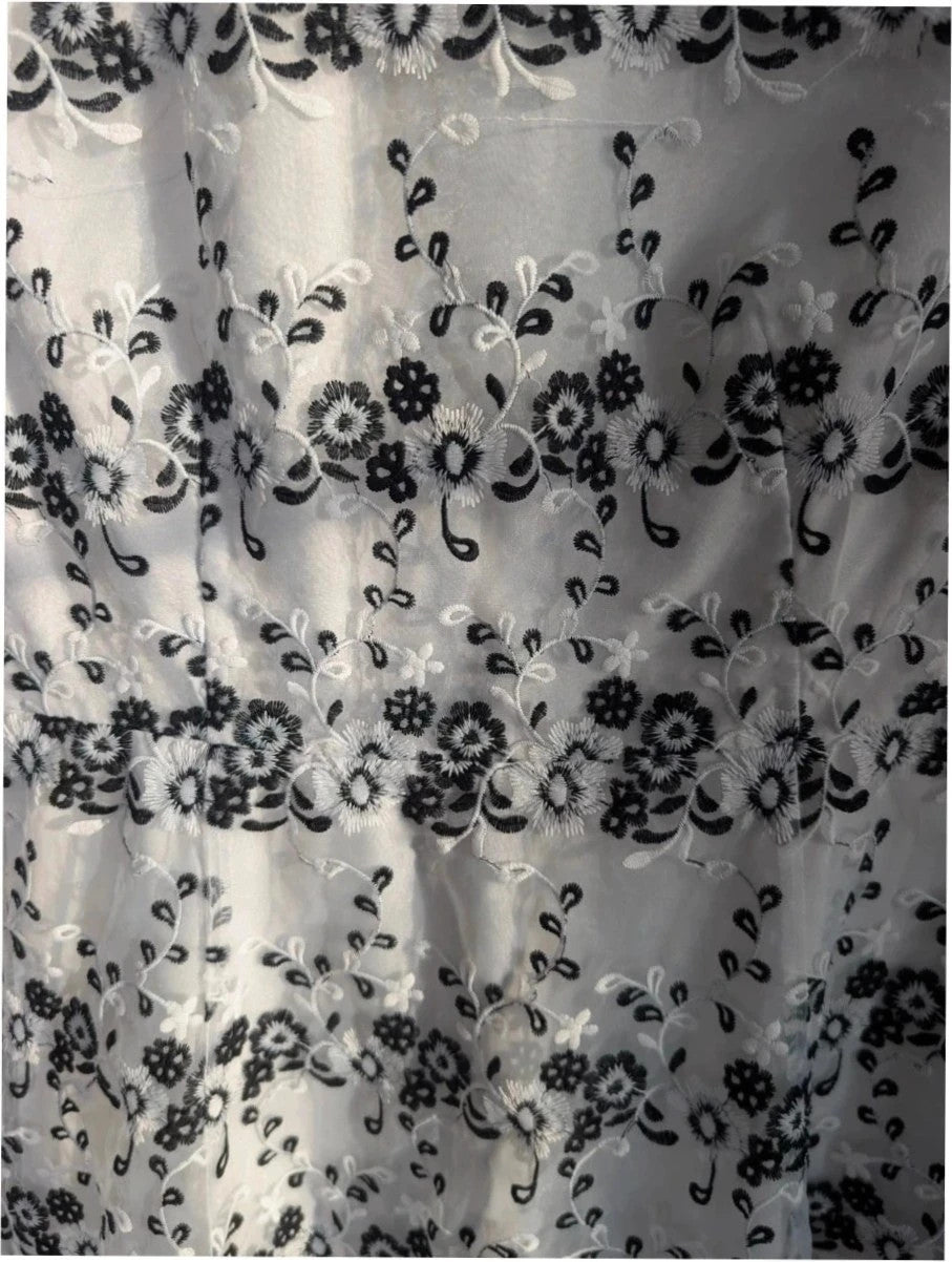 Yumi black and white floral embroidered mesh overlay dress with fitted waist and flared skirt.