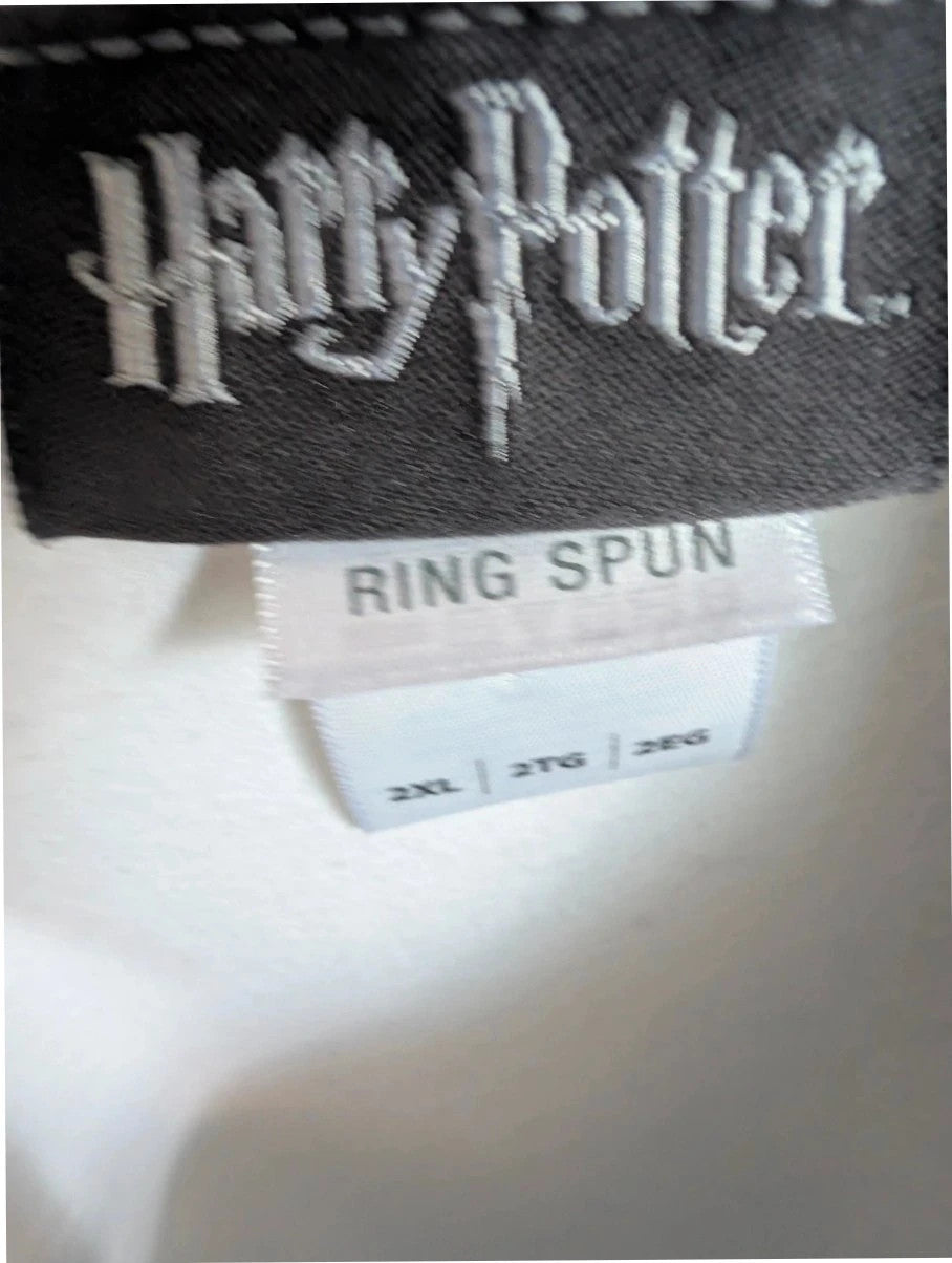 Harry Potter white graphic tee featuring green Slytherin crest and coiling snake design.