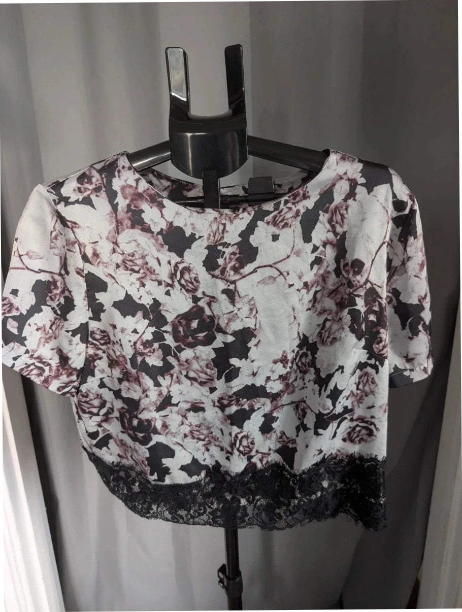 NaaNaa black satin crop top with floral print and eyelash lace trim.