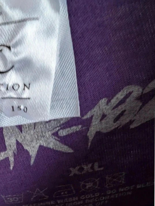 Blink-182 purple graphic t-shirt featuring smiley face logo with neon pink drip detailing.