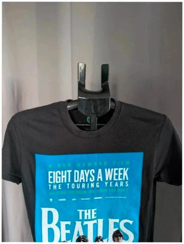 The Beatles black graphic tee featuring vibrant blue and white documentary print.