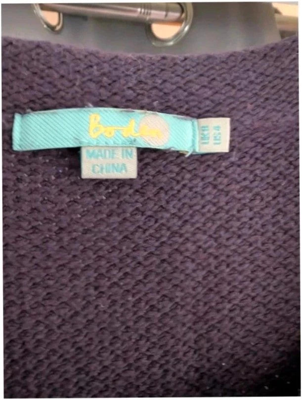 Purple knit sweater dress with long sleeves, relaxed fit, and functional front pockets.