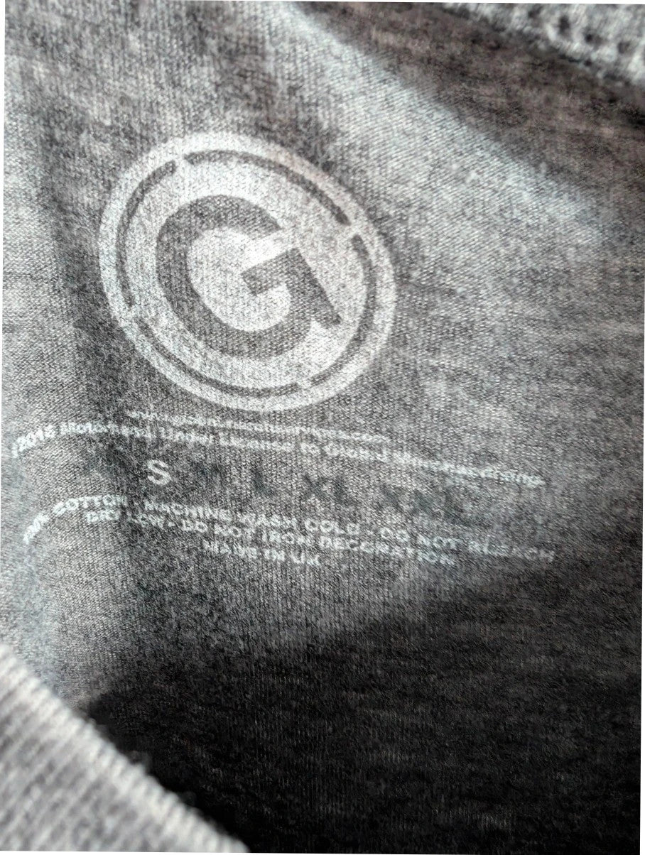 Motörhead grey graphic tee featuring Snaggletooth Warpig emblem and circular print.
