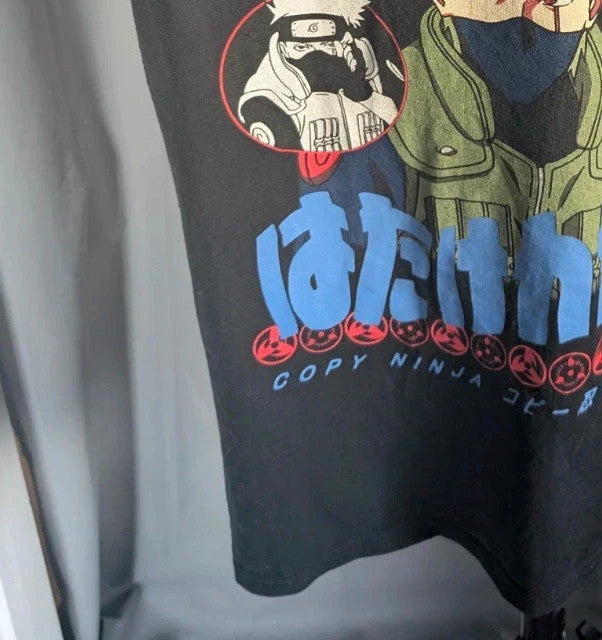 Naruto black graphic t-shirt featuring Kakashi Hatake, bubble typography, and Sharingan eye design.