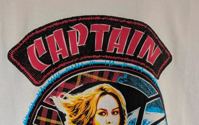 Marvel white graphic t-shirt featuring Captain Marvel print and retro patch-style lettering.