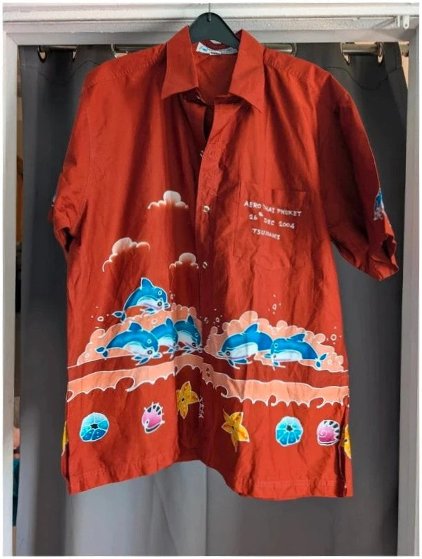 Phuket Batik burgundy graphic tee with hand-painted dolphins and commemorative embroidered pocket.