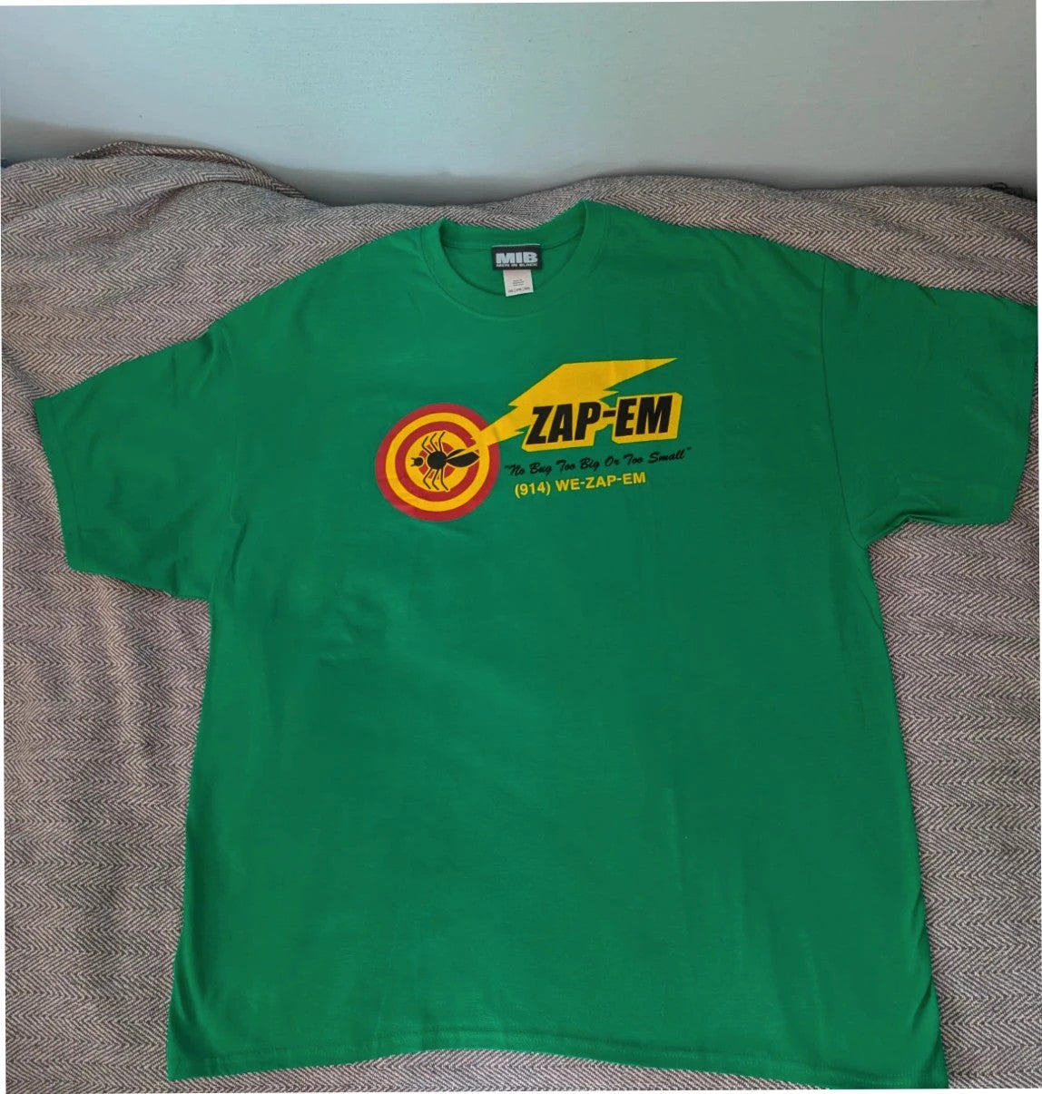 Gildan green graphic tee featuring Men In Black "Zap-Em Exterminators" logo and slogan.