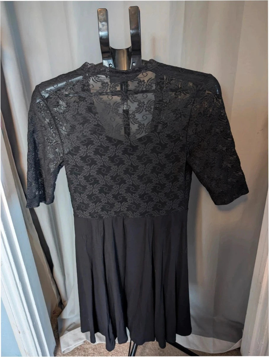 Bodyflirt black skater dress with floral lace yoke, deep V-neckline, and pleated skirt.