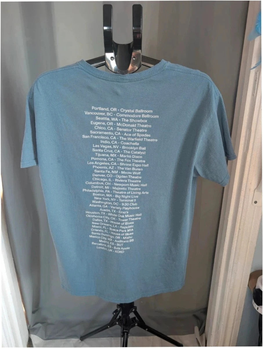 Omar Apollo blue graphic t-shirt with portrait print and tour date list on back.