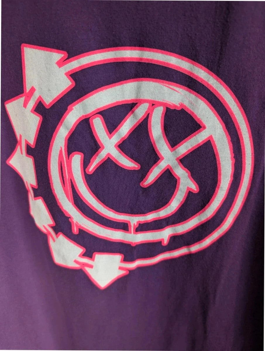 Blink-182 purple graphic t-shirt featuring smiley face logo with neon pink drip detailing.