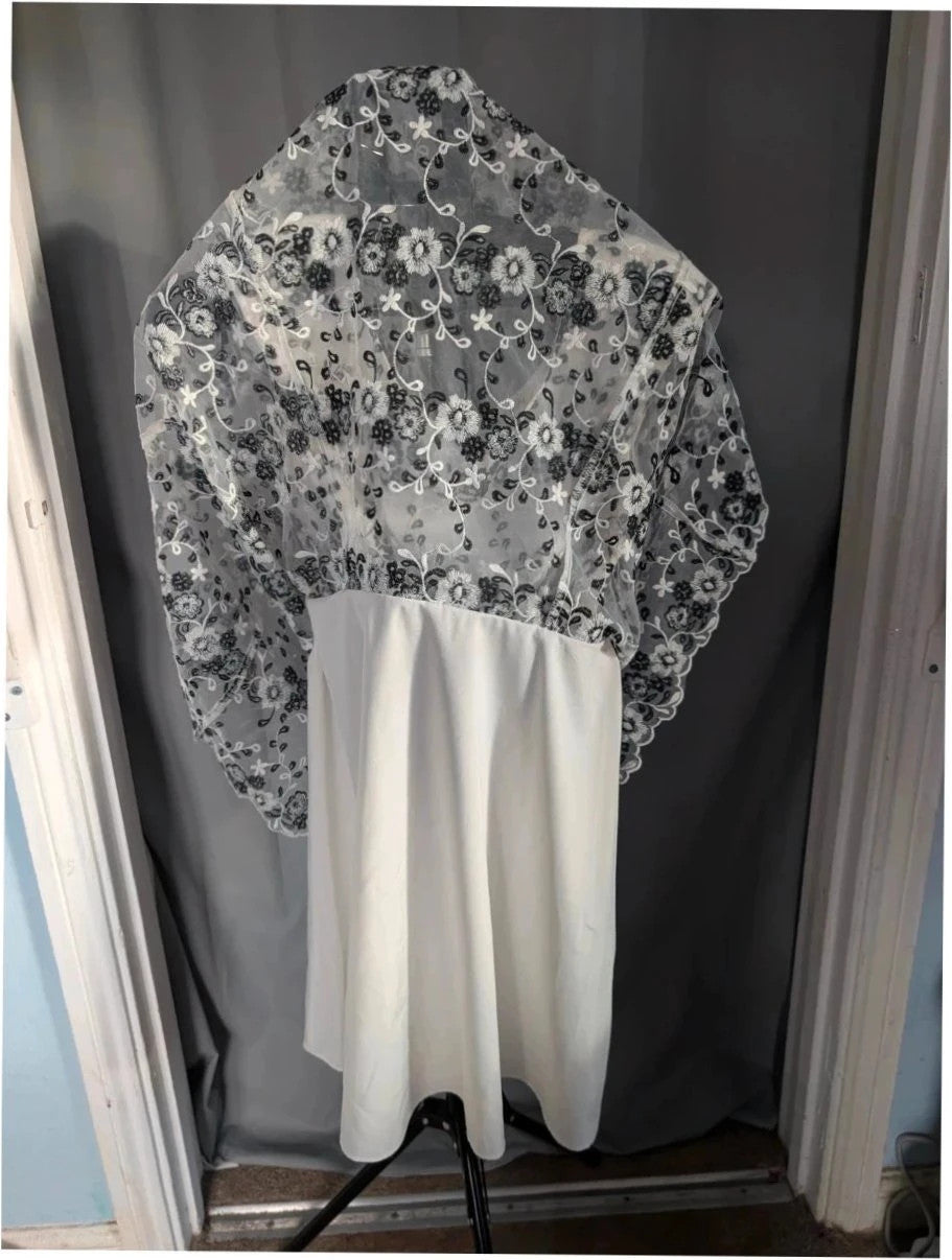 Yumi black and white floral embroidered mesh overlay dress with fitted waist and flared skirt.