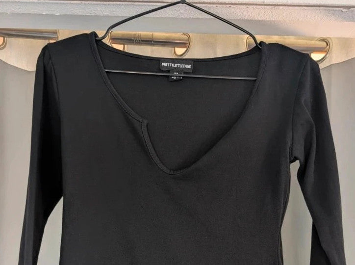 PrettyLittleThing black long sleeve bodycon mini dress with notch neck and fitted sleeves.