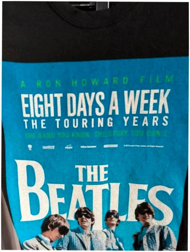 The Beatles black graphic tee featuring vibrant blue and white documentary print.