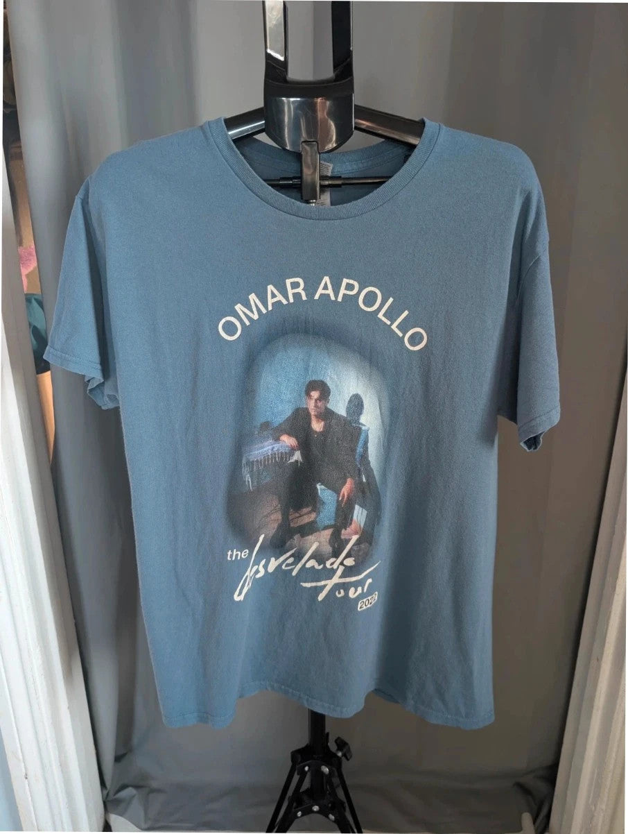 Omar Apollo blue graphic tee featuring portrait print and tour date list on back.