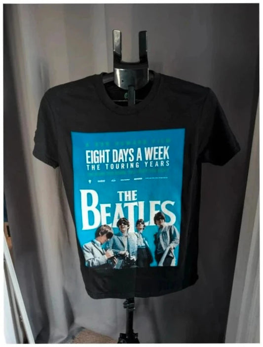 The Beatles black graphic tee featuring vibrant blue and white documentary print.