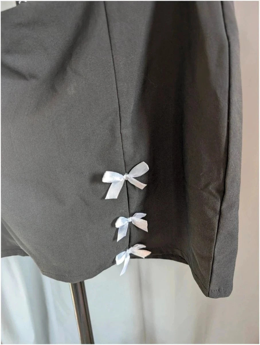 PrettyLittleThing black mini skirt with white satin bow detail and high-waisted fit.