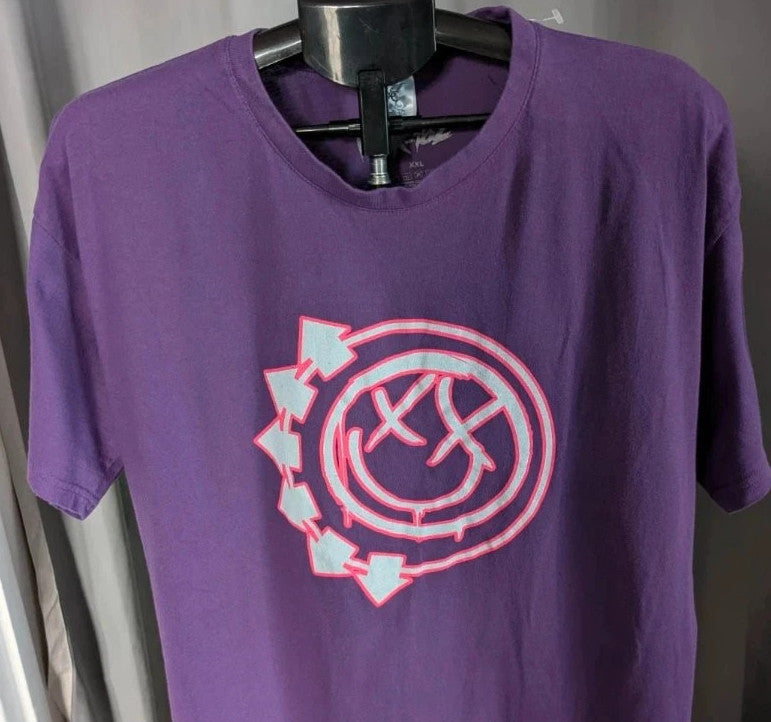 Blink-182 purple graphic t-shirt featuring smiley face logo with neon pink drip detailing.