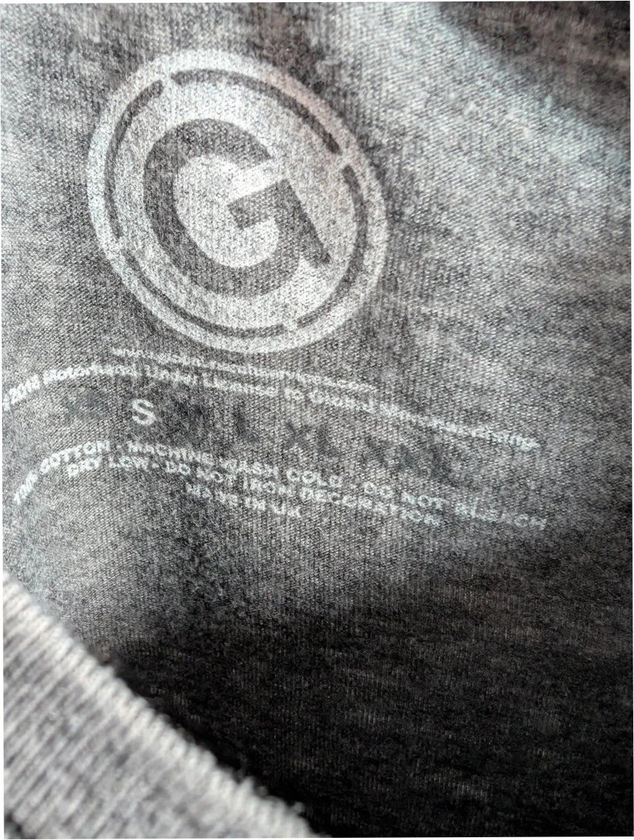 Motörhead grey graphic tee featuring Snaggletooth Warpig emblem and circular print.