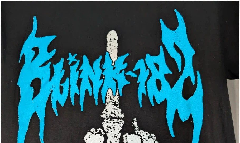 Blink 182 black graphic tee with blue skeleton middle finger design and crew neck.