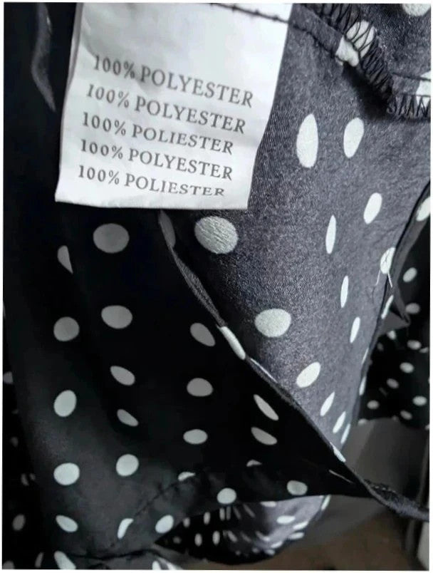 Voyelles black and white polka dot blouse with ruffle collar and button-up front.