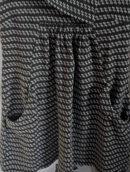 Apricot black and grey knit tunic dress with cowl neck and geometric pattern.