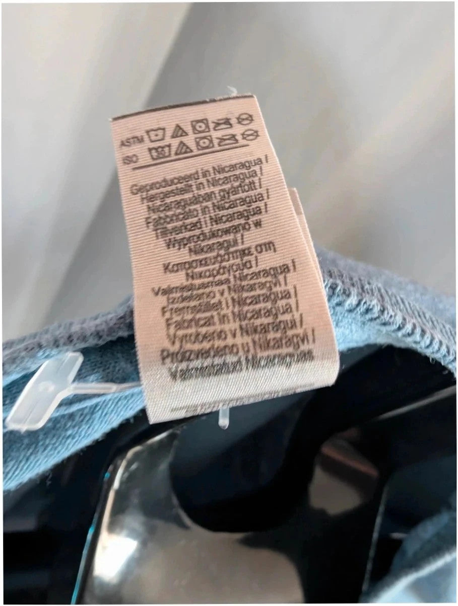 Omar Apollo blue graphic t-shirt with portrait print and tour date list on back.