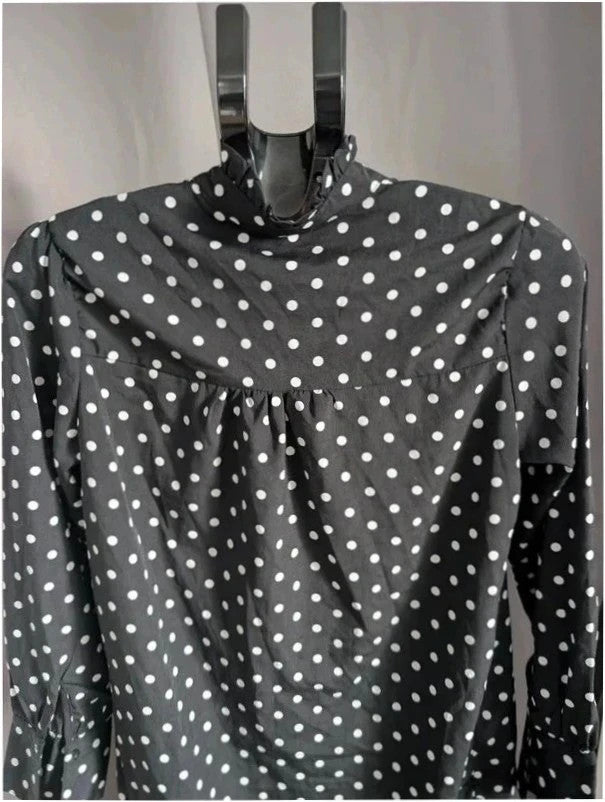 Voyelles black and white polka dot blouse with ruffle collar and button-up front.