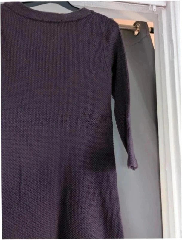 Purple knit sweater dress with long sleeves, relaxed fit, and functional front pockets.