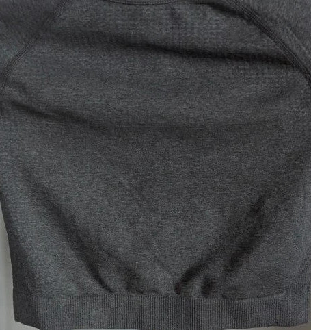 Pink Elephant black gym crop top with white logo, seamless design, and thumbhole cuffs.