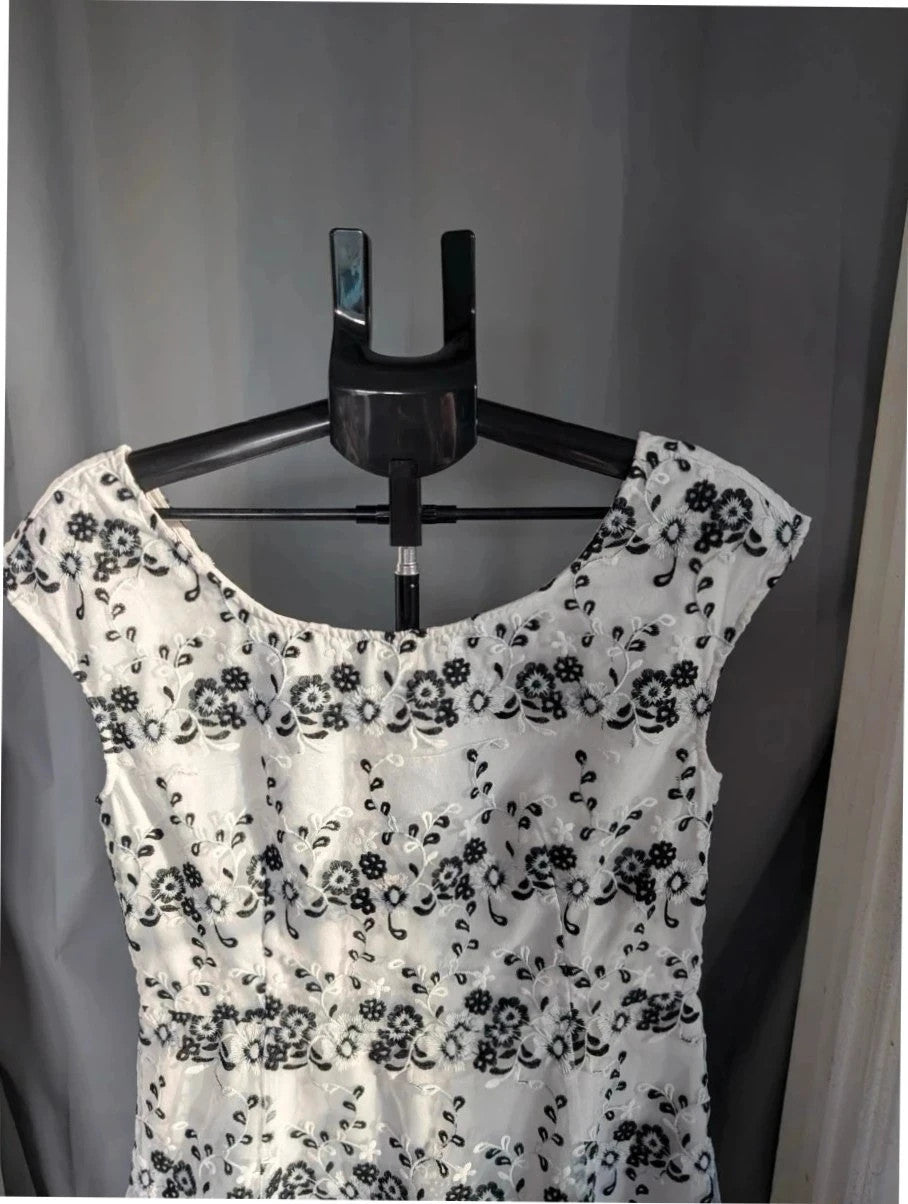 Yumi black and white floral embroidered mesh overlay dress with fitted waist and flared skirt.