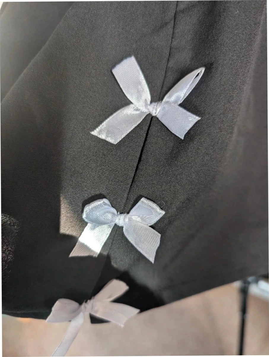 PrettyLittleThing black mini skirt with white satin bow detail and high-waisted fit.