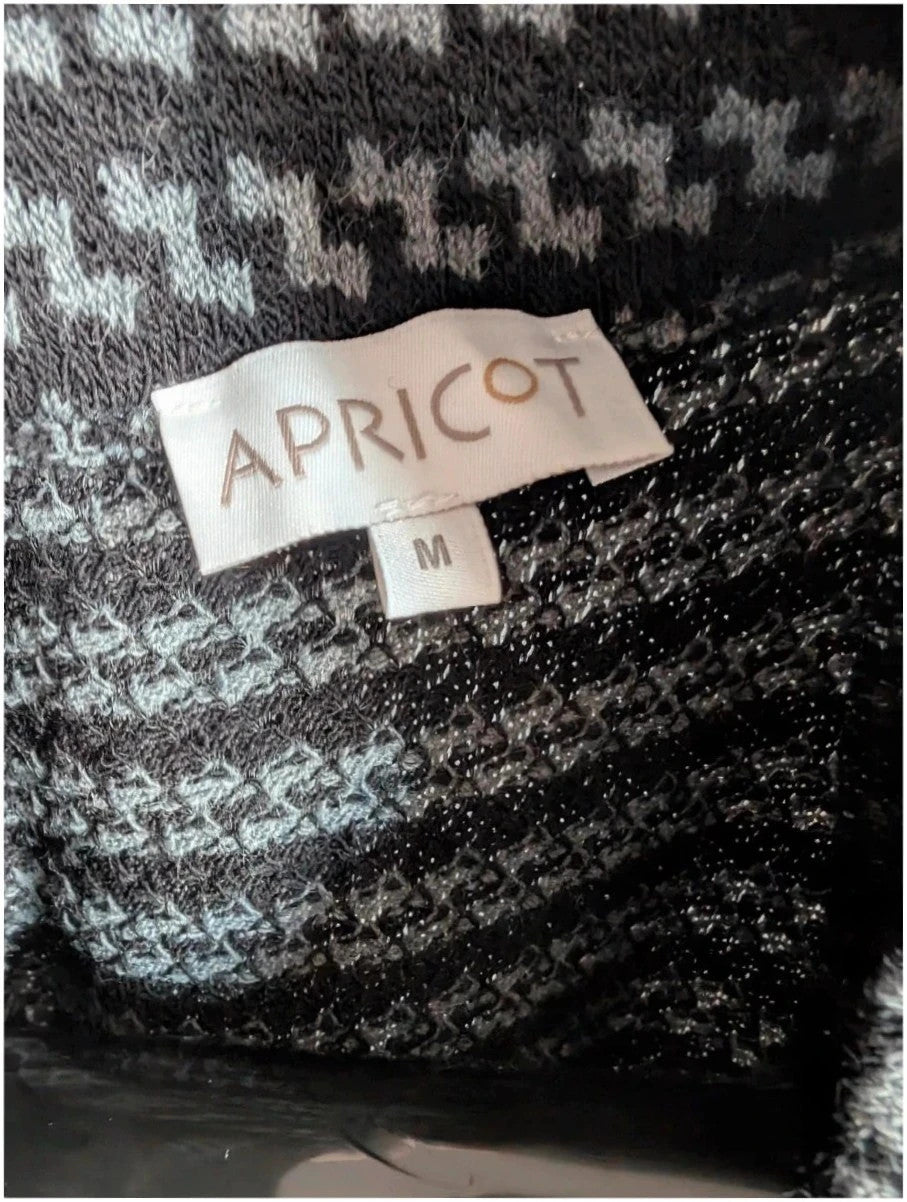 Apricot black and grey knit tunic dress with cowl neck and geometric pattern.