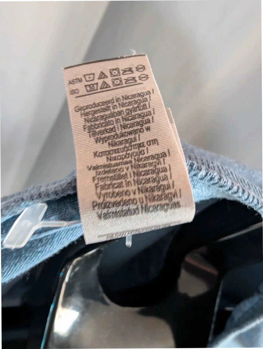 Omar Apollo blue graphic tee featuring portrait print and tour date list on back.