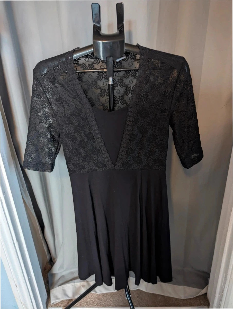 Bodyflirt black skater dress with floral lace yoke, deep V-neckline, and pleated skirt.
