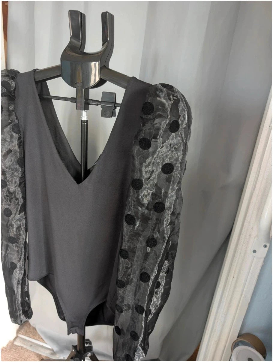 New Look black bodysuit with mesh polka dot sleeves and plunge V-neckline.