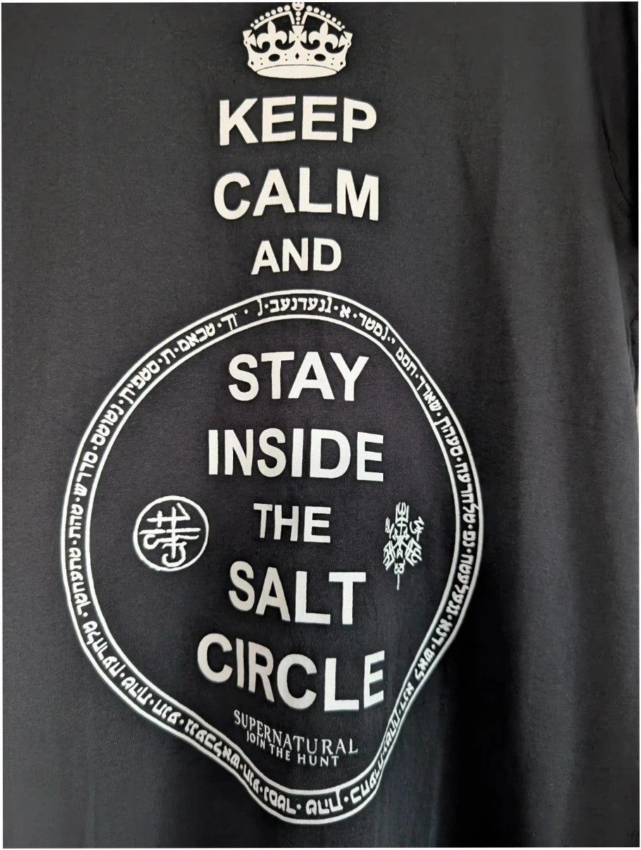 Supernatural black pocket t-shirt with "Stay Inside Salt Circle" graphic and symbols.